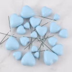 Set de 20 de inimi bleu pal 3D din polistiren pe tije metalice si un tort alb cu textura fina decorat delicat cu aceste ornamente in forma de inima