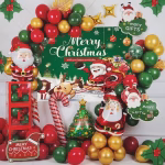 Kit decorativ de Craciun continand un fundal verde textil cu mesajul Merry Christmas, inconjurat de o arcada organica din baloane rosii, verzi si aurii, figurine din folie reprezentand pe Mos Craciun, un brad impodobit si o acadea, completate de accesorii din carton tematic