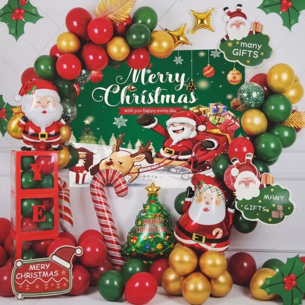 Kit decorativ de Craciun continand un fundal verde textil cu mesajul Merry Christmas, inconjurat de o arcada organica din baloane rosii, verzi si aurii, figurine din folie reprezentand pe Mos Craciun, un brad impodobit si o acadea, completate de accesorii din carton tematic