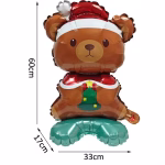 Balon 3D din folie reprezentand un ursulet maro de Craciun purtand o caciula specifica, pelerina rosie si tinand un bradut verde decorat, avand o baza verde pentru stabilitate pe podea