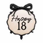 Balon din folie in forma de medalion pentru majorat avand un fundal crem inconjurat de o margine neagra ondulata decorat in partea superioara cu o funda neagra si textul caligrafic Happy 18 in centru