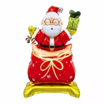 Balon din folie metalizată de tip standing, înfățișându-l pe Moș Crăciun cu ochelari rotunzi, ieșind dintr-un sac roșu cu cadouri decorat cu fulgi de nea și o fundă aurie, ținând în mâini un cadou verde și o acadea bastonaș, totul așezat pe o bază aurie de susținere