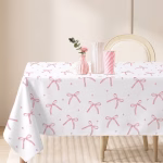Fata de masa dreptunghiulara de culoare alba decorata cu un model repetitiv format din fundite roz elegante cu aspect de acuarela si mici stelute roz