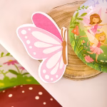 Set de trei servetele de masa decupate elegant in forma de fluture din profil cu aripi detaliate in nuante pastelate calde de roz portocaliu si mov