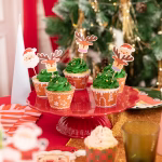 Set de 10 toppere din carton pentru tort și brioșe, format din 5 decupaje cu chipul lui Moș Crăciun și 5 decupaje cu fețe de reni simpatici purtând fulare colorate de iarnă