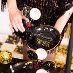 Set de 6 toppere rotunde din carton pentru tort de Revelion, ilustrând fețe de ceas care indică apropierea miezului nopții, dintre care trei au fundal alb cu contur auriu și trei au fundal negru cu detalii aurii