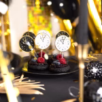 Set de 6 toppere rotunde din carton pentru tort de Revelion, ilustrând fețe de ceas care indică apropierea miezului nopții, dintre care trei au fundal alb cu contur auriu și trei au fundal negru cu detalii aurii