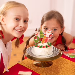 Set de 6 toppere din carton pentru tort, ilustrând figurine clasice de Crăciun: o șosetă roșie decorată, un brad împodobit cu o stea în vârf, Moș Crăciun zâmbitor, o stea căzătoare zâmbitoare, un om de zăpadă cu fular roșu și o coroniță verde cu fundă roșie