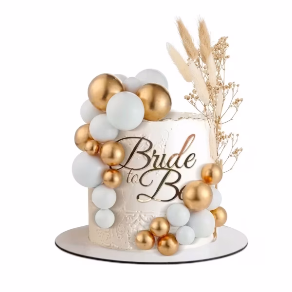 Tort alb texturat decorat cu o cascada eleganta formata din sfere de polistiren in culorile alb si auriu lucios, acompaniate de un topper Bride to Be si flori uscate decorative