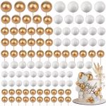 Tort alb texturat decorat cu o cascada eleganta formata din sfere de polistiren in culorile alb si auriu lucios, acompaniate de un topper Bride to Be si flori uscate decorative