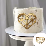 Topper de tort tip charm din acril oglinda aurie avand forma unei inimi decupate in stil geometric, compusa din linii drepte intersectate ce imita fatetele unui diamant