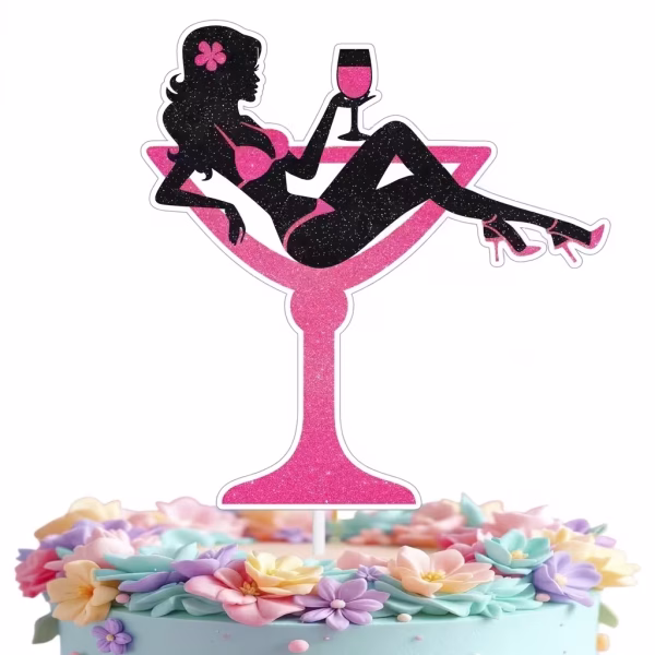 Tort decorat cu flori pastelate, avand in varf un topper din carton cu sclipici reprezentand o silueta feminina neagra asezata intr-un pahar mare de cocktail roz, tinand un pahar mic in mana