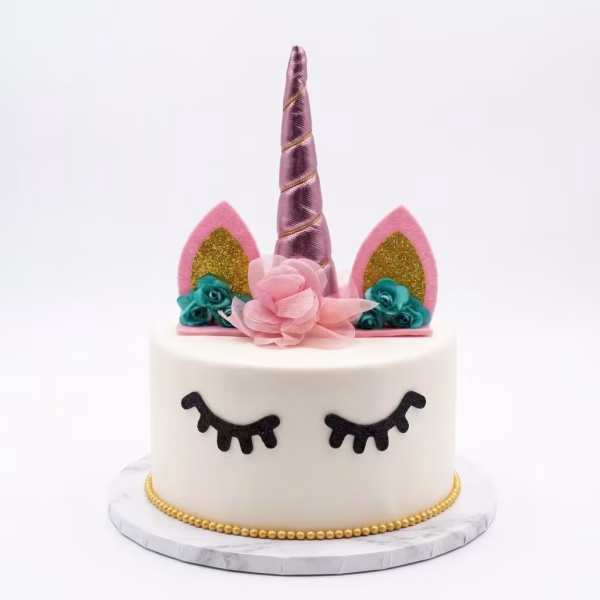 Tort alb decorat cu un topper unicorn 3D avand corn roz metalizat si urechi cu sclipici auriu, alaturi de ochi din carton negru aplicati pe glazura frontala
